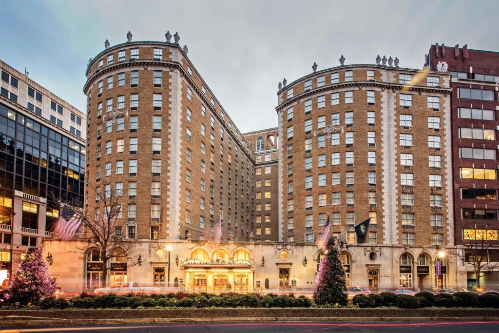 华盛顿Marriott Vacation Club® at the Mayflower, Washington, D.C. 的两座高大的建筑,前面有圣诞树