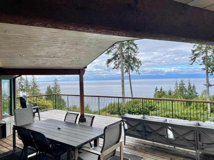 半月湾Barooga: Stunning View Home in Halfmoon Bay, Canada的观景甲板上的木桌和椅子