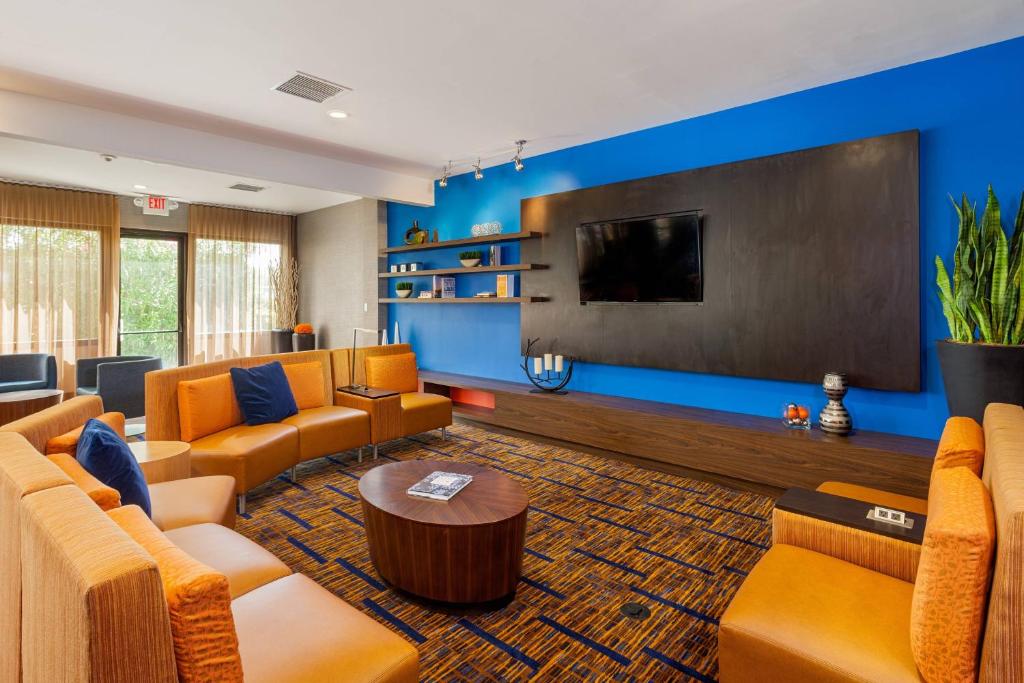 费尔菲尔德纳帕谷地区费尔菲尔德万怡酒店的大型客厅配有橙色沙发和平面电视。
