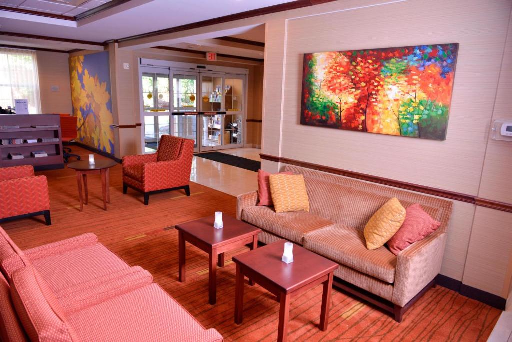 米德尔堡米德尔伯里万怡酒店的客厅配有沙发、桌子和绘画作品