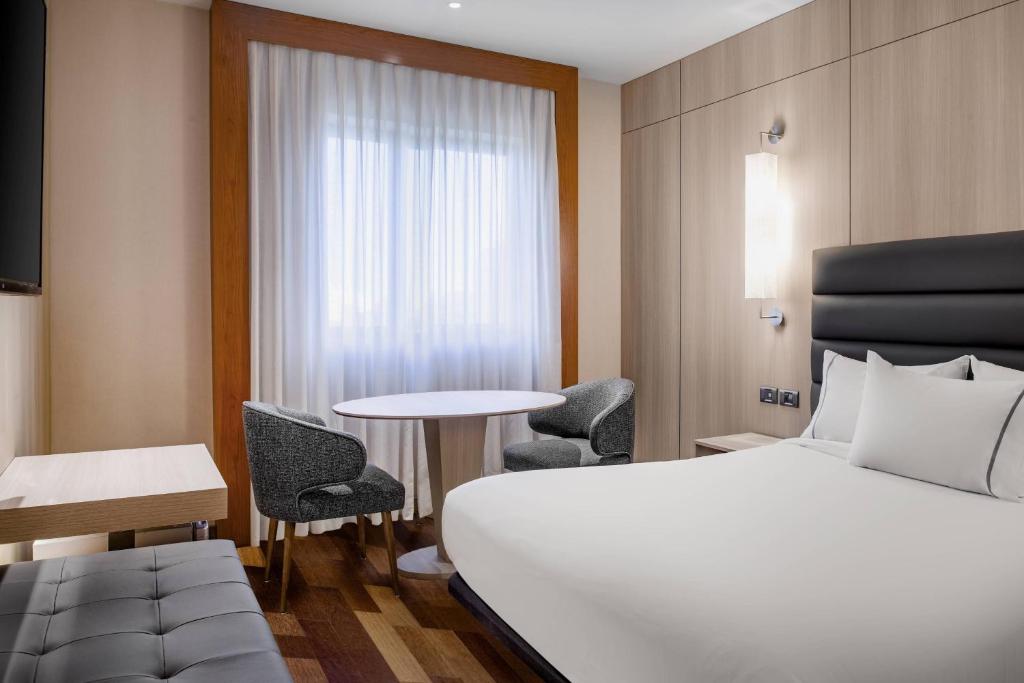 塔拉戈纳塔拉戈纳万豪AC酒店的酒店客房带一张床、一张桌子和椅子