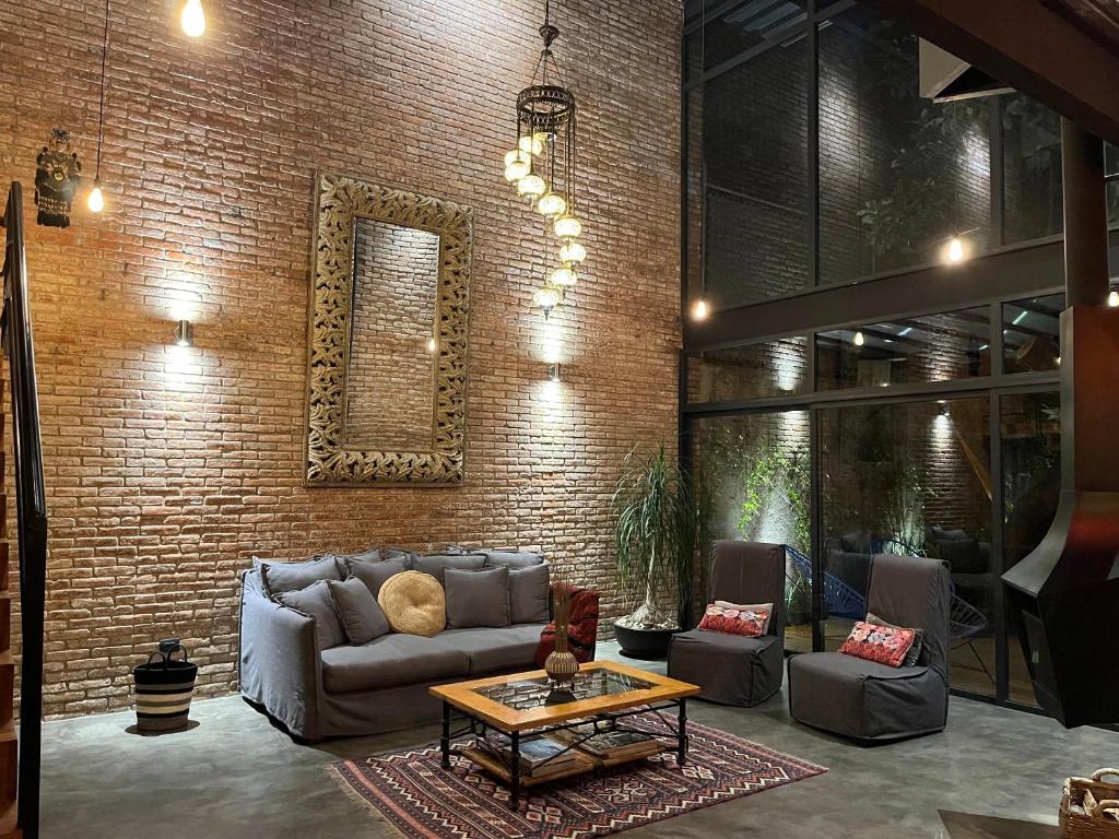 墨西哥城Mi Refugio San Angel的带沙发和砖墙的客厅