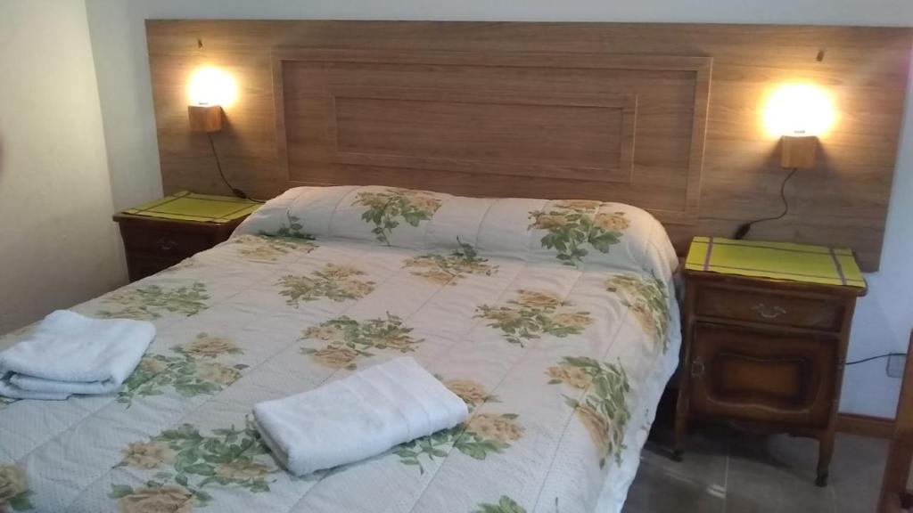 奥拉瓦里亚Mi Lugar的一张带两个床头柜和两个毛巾的床