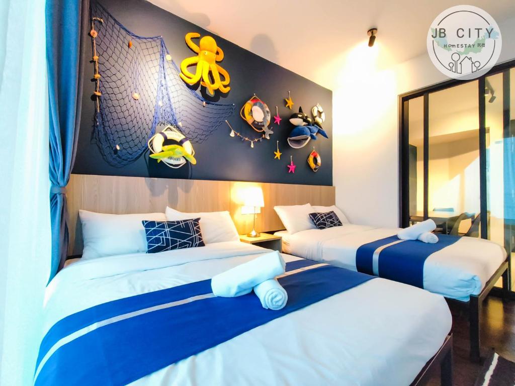 努沙再也Almas Suites by JBcity Home的两张位于酒店客房的床铺,配有带贴纸的墙壁