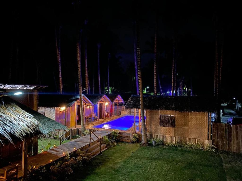 锡基霍尔The Bangka Beach Guesthouse的享有带游泳池的度假村的夜景