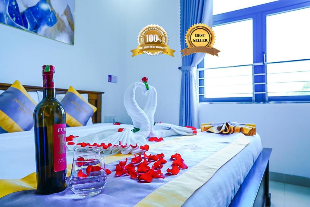 昆岛Côn Sơn Victory Hotel的床上有一瓶葡萄酒和天鹅