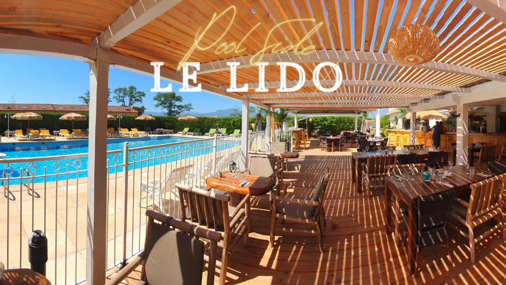 卢恰纳里多酒店的一个带桌椅的庭院和一个游泳池