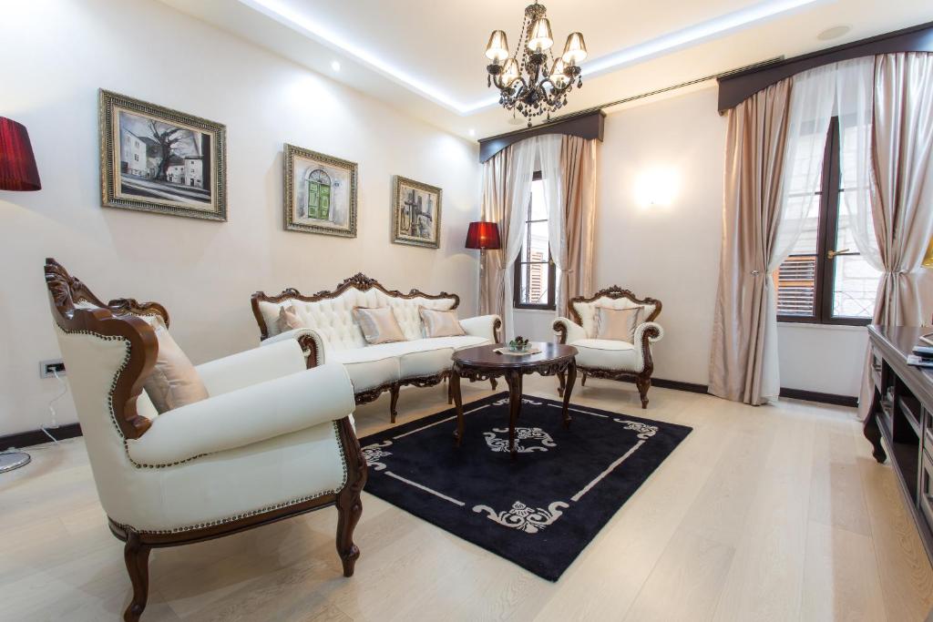 科托尔明珠公寓的客厅配有白色家具和吊灯。