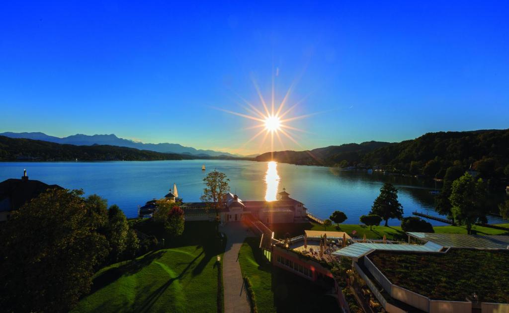 沃尔特湖畔佩莎赫Werzers Hotel Resort Pörtschach的享有湖泊美景,阳光照耀在水面上