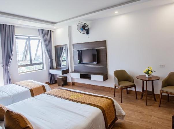 岑山Tan Truong Son Legacy Hotel的酒店客房设有两张床和一台平面电视。