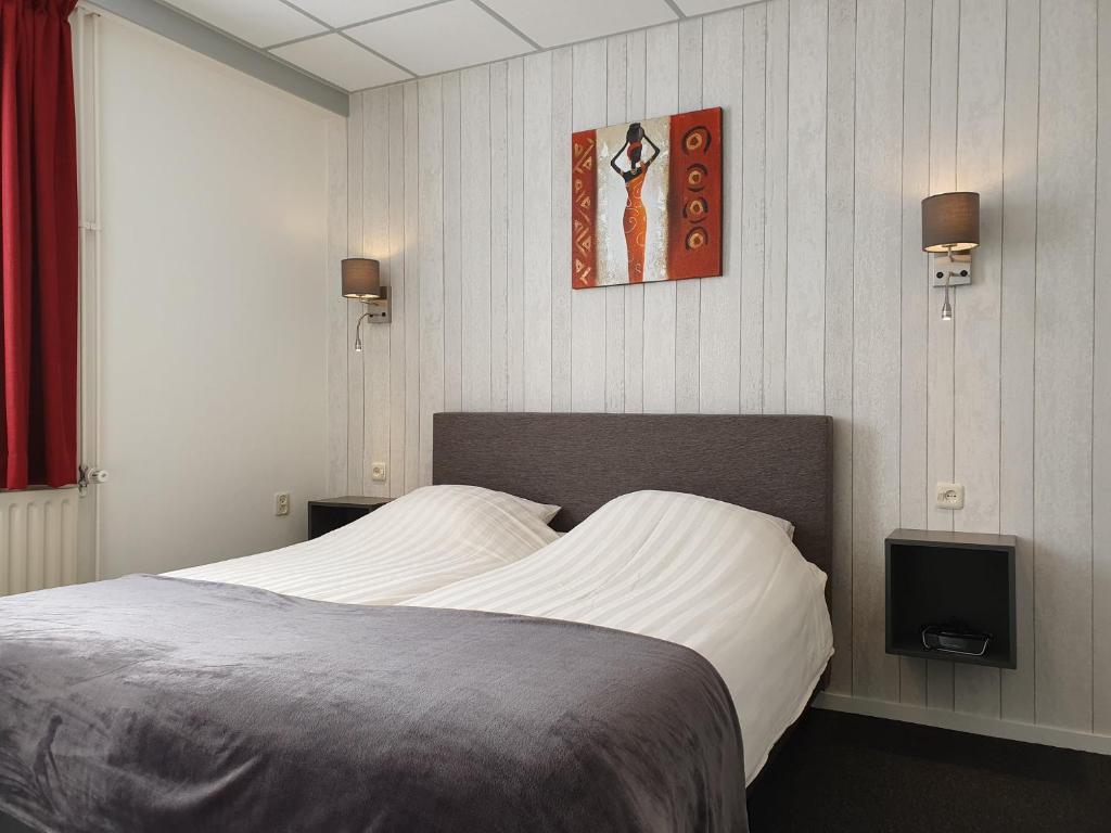 梅赫伦Appartementen Vouwere的卧室配有一张床,墙上配有电视。