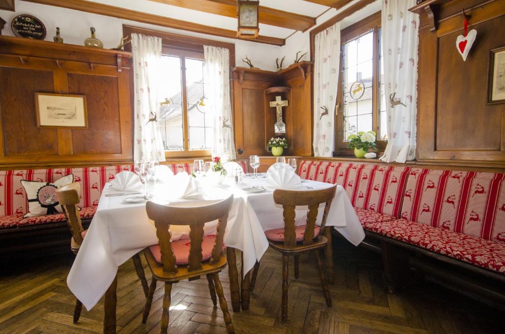 胡根尔舍姆赫施巴迪彻兰德霍夫旅馆的一间配备有白色桌椅的用餐室