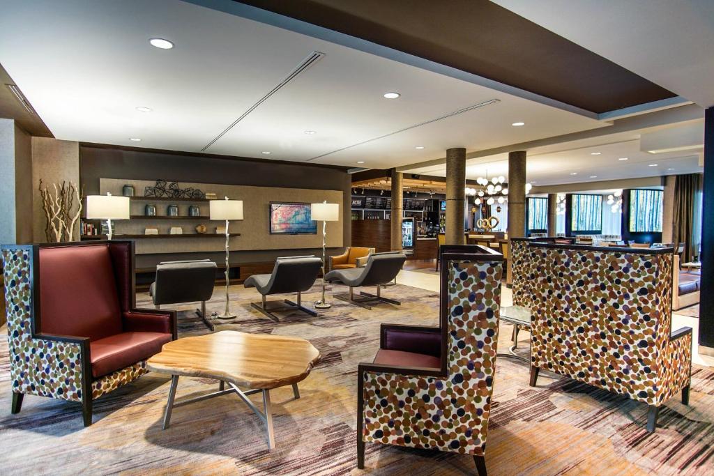 莱诺克斯Courtyard by Marriott Lenox Berkshires的大堂设有桌椅和酒吧。