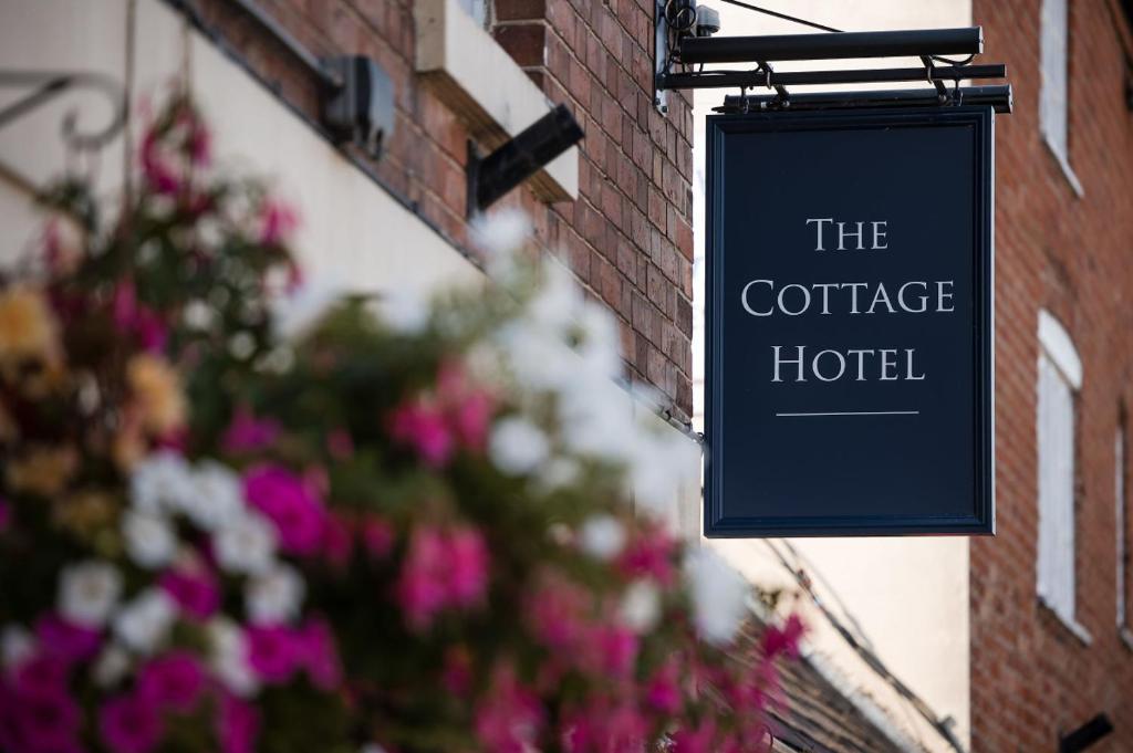 诺丁汉The Cottage Hotel的挂在一座大楼上的咖啡旅馆读书的标志