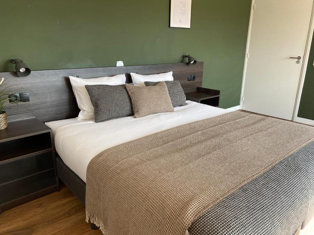 兹沃勒Buitenplaats de Luwte的卧室配有一张带白色床单和枕头的大床。