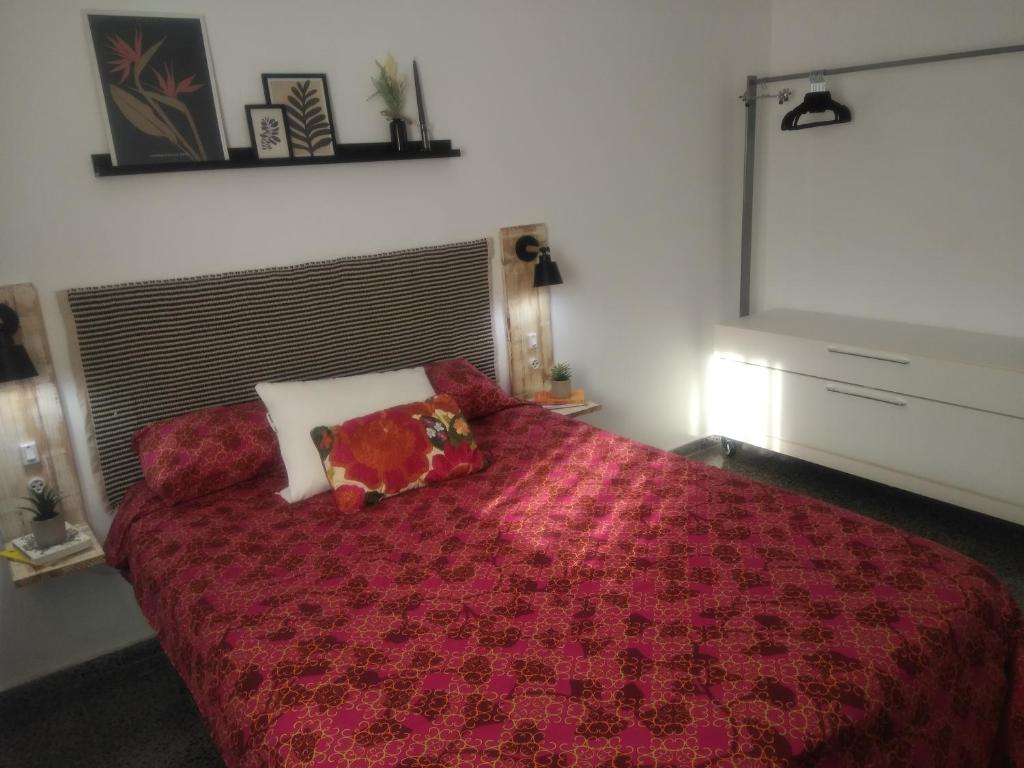 塞维利亚Sevilla Macarena apartamento 3 dormitorios的一间卧室配有红色的床和两个枕头