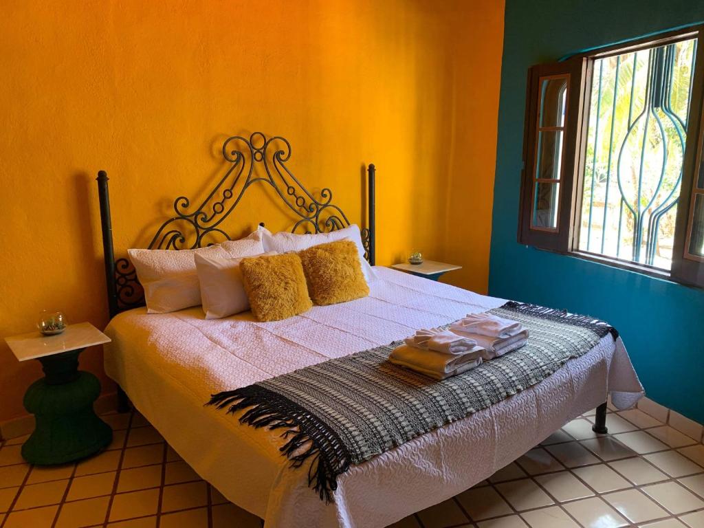 巴亚尔塔港VILLA OASIS的一间卧室设有一张黄色墙壁的床