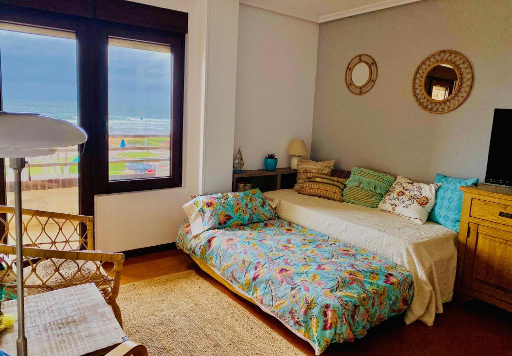 擞莫Vistas al Mar的一间卧室配有一张床、一张沙发和一个窗口