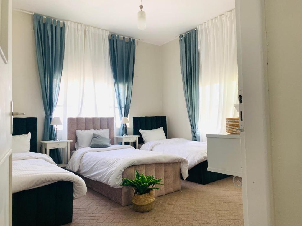 马达巴Laura's Cozy HOME的一间卧室配有2张蓝色窗帘