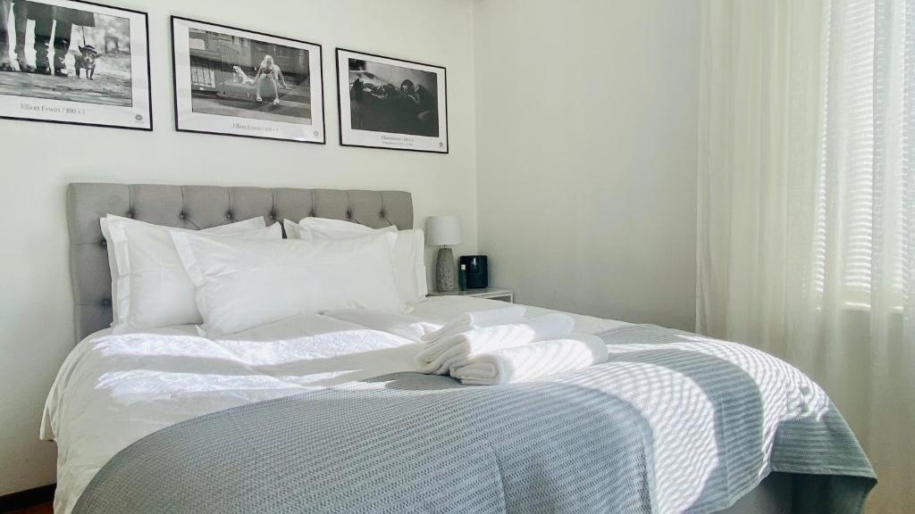 松兹瓦尔Sundsvall by M - Apartment的卧室配有一张白色床,墙上挂有照片