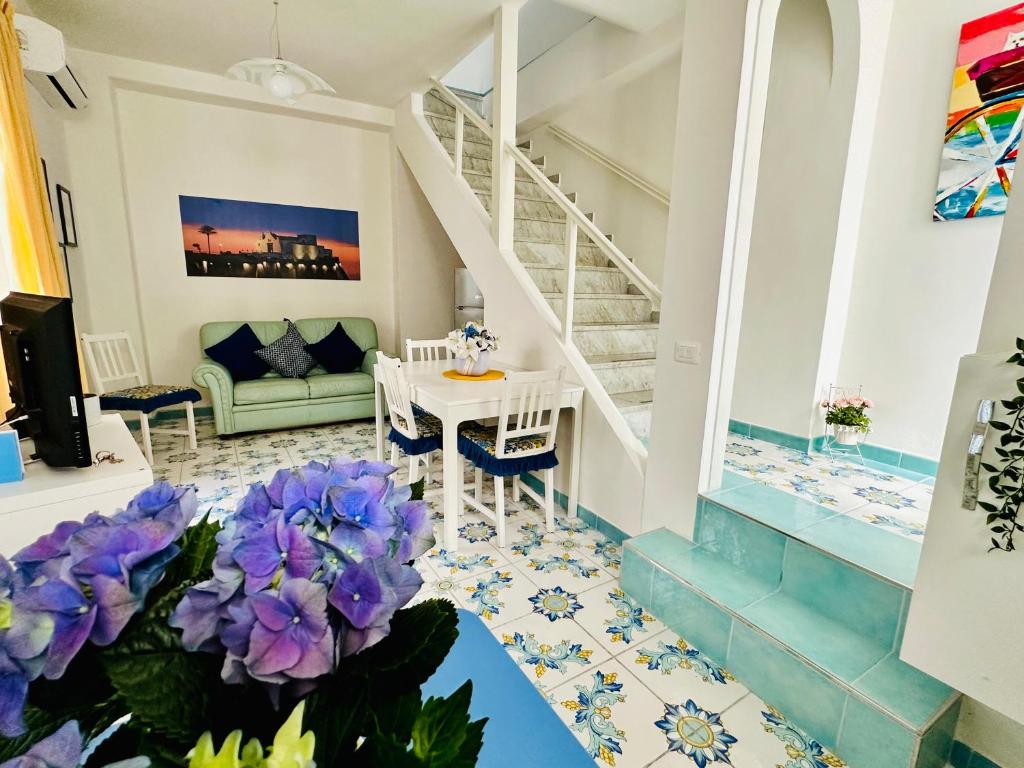 伊斯基亚Blue Apartment的客厅设有楼梯和紫色鲜花