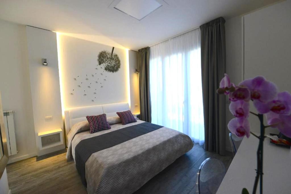 马里纳-迪-皮特拉桑塔La Brise的一间卧室,配有一张床和紫色花瓶