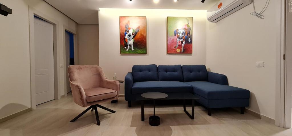 埃拉特Yuval holidey aprtment eilat的客厅配有蓝色的沙发和椅子
