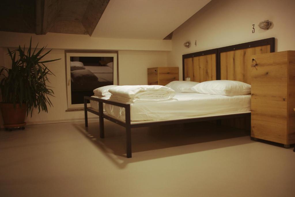 新戈里察GARAGE HOSTEL的一间卧室配有一张大床和木制床头板