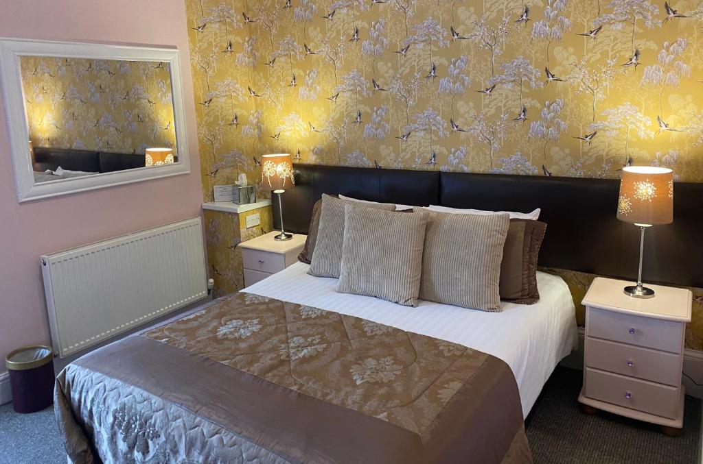 卡莱尔对角地旅馆的一间卧室设有一张大床和黄色的墙壁