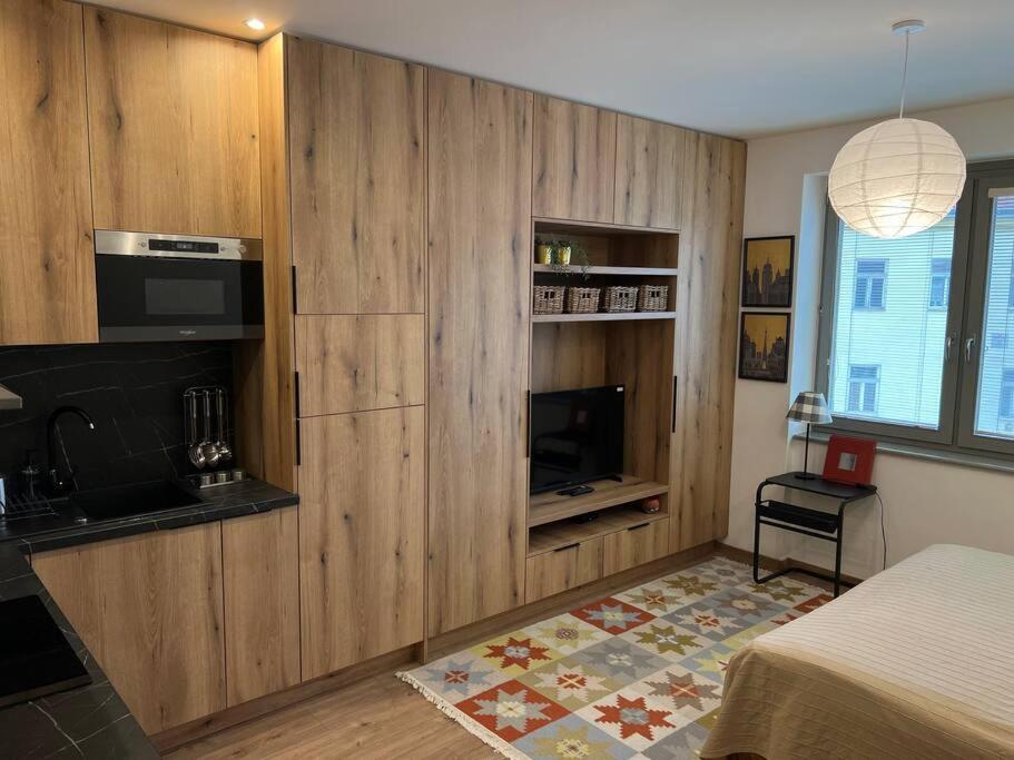 科希策Nové bývanie v centre Košíc.的一间卧室配有木制橱柜、一张床和一台电视机。