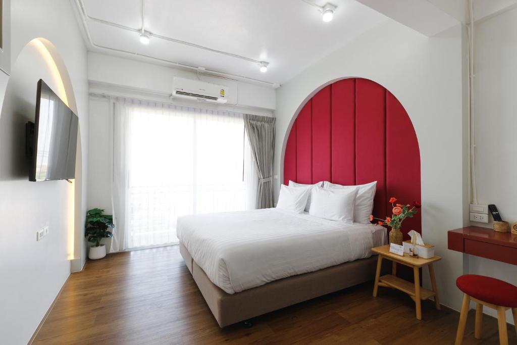 清莱Grow home -Stay and space, Self check-in的一间卧室配有一张大床和红色床头板