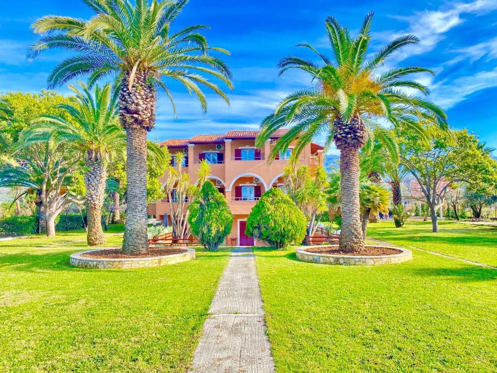 阿尔米罗斯海滩Villa Pami的棕榈树成荫的通道,在粉红色的建筑前
