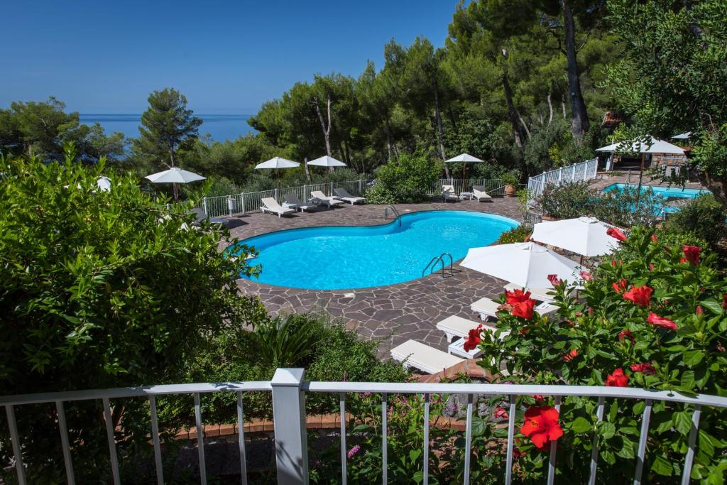 马拉泰亚戴尔梅拉维格力别墅酒店的享有带椅子和遮阳伞的游泳池的景色