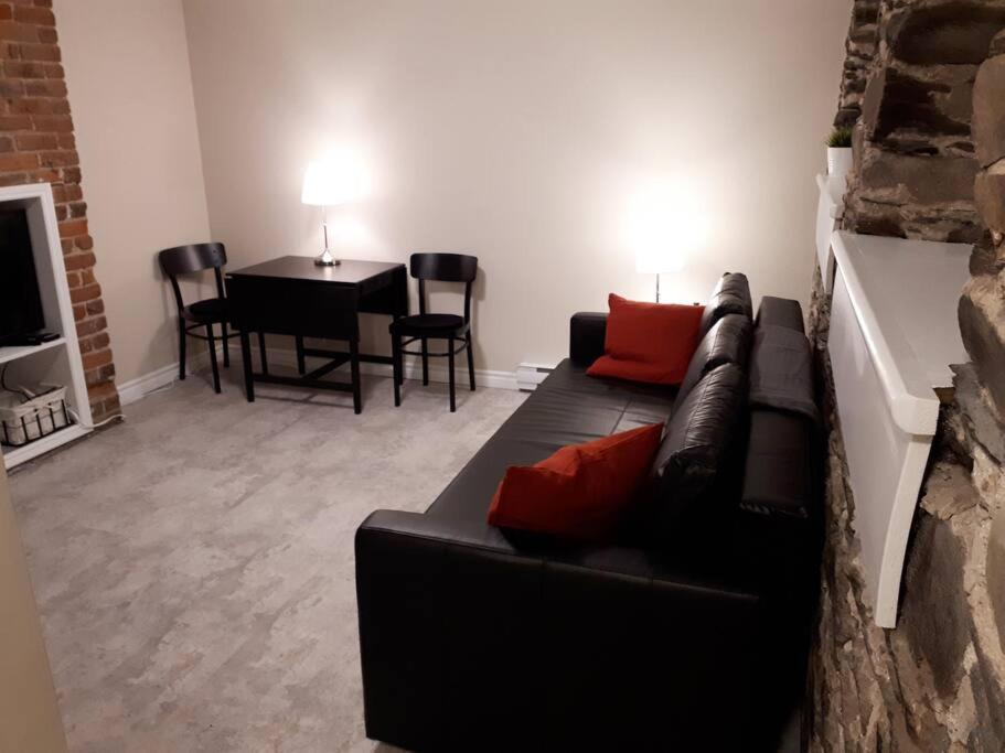 哈利法克斯Bauer Terrace - Cozy 1 bedroom beside The Citadel的客厅配有黑色沙发和桌子