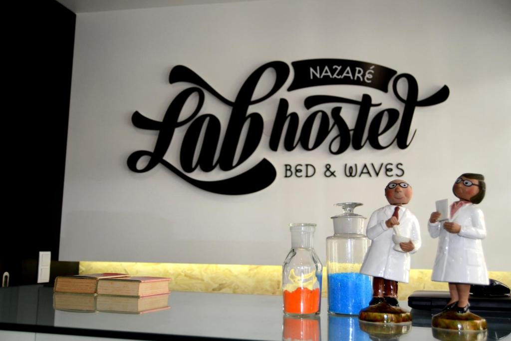 纳扎雷Lab Hostel Nazare的标牌前方有两幅图表的桌子