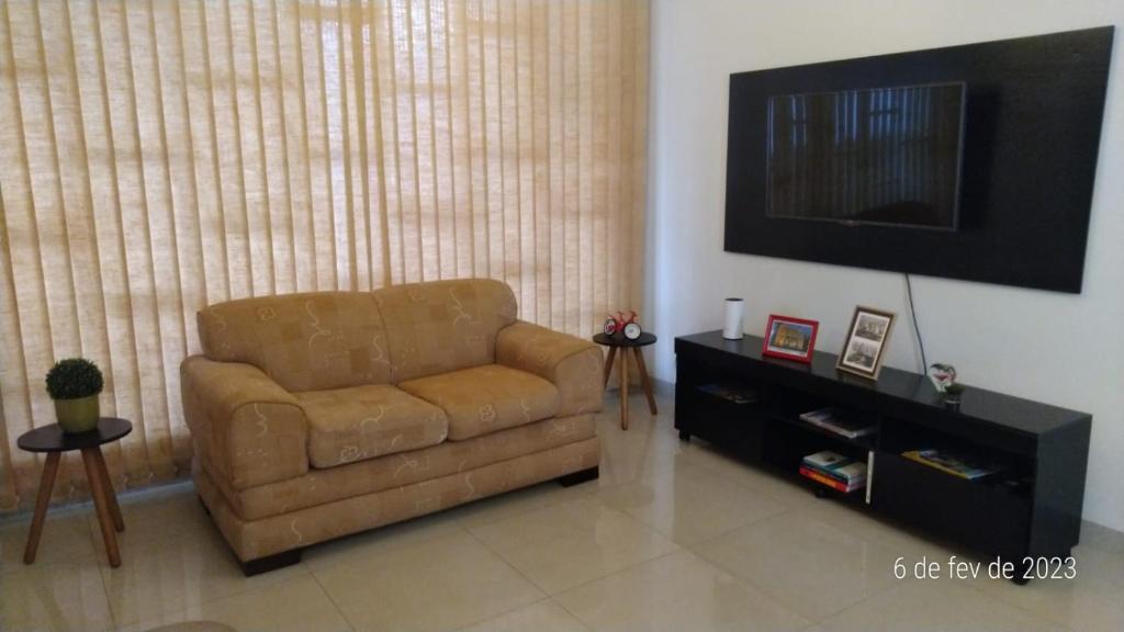 乌贝兰迪亚Apartamento Uberlândia - Centro com garagem的客厅里设有一张棕色的皮沙发,配有电视