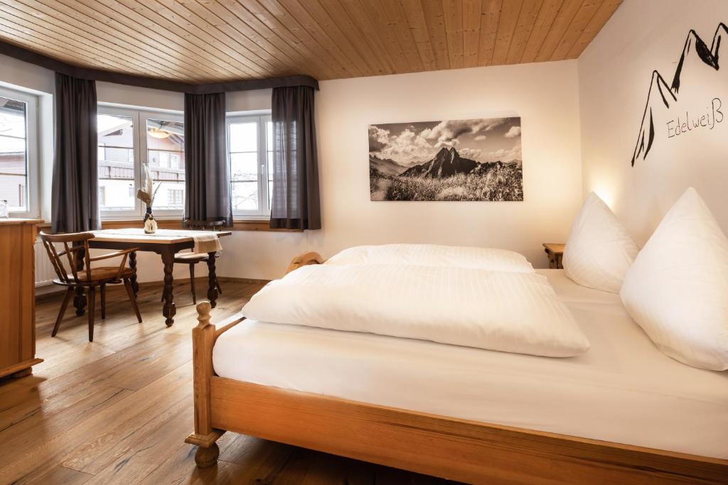 奥伯斯特多夫Landgasthof Augustiner的一间卧室配有一张大床和一张桌子