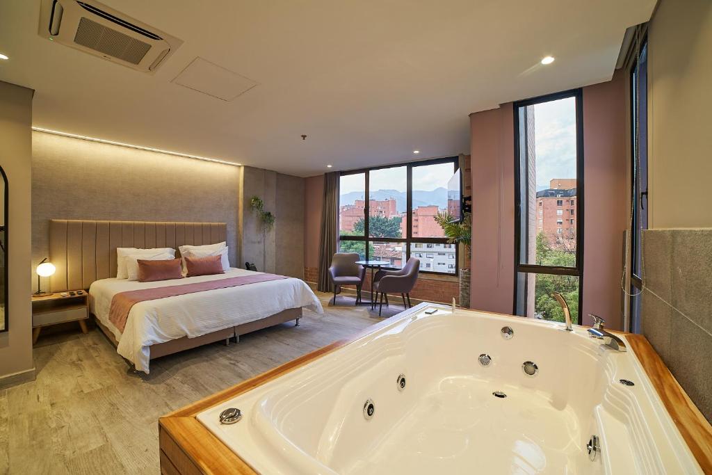 麦德林Eutopiq Hotel的卧室配有床和浴缸