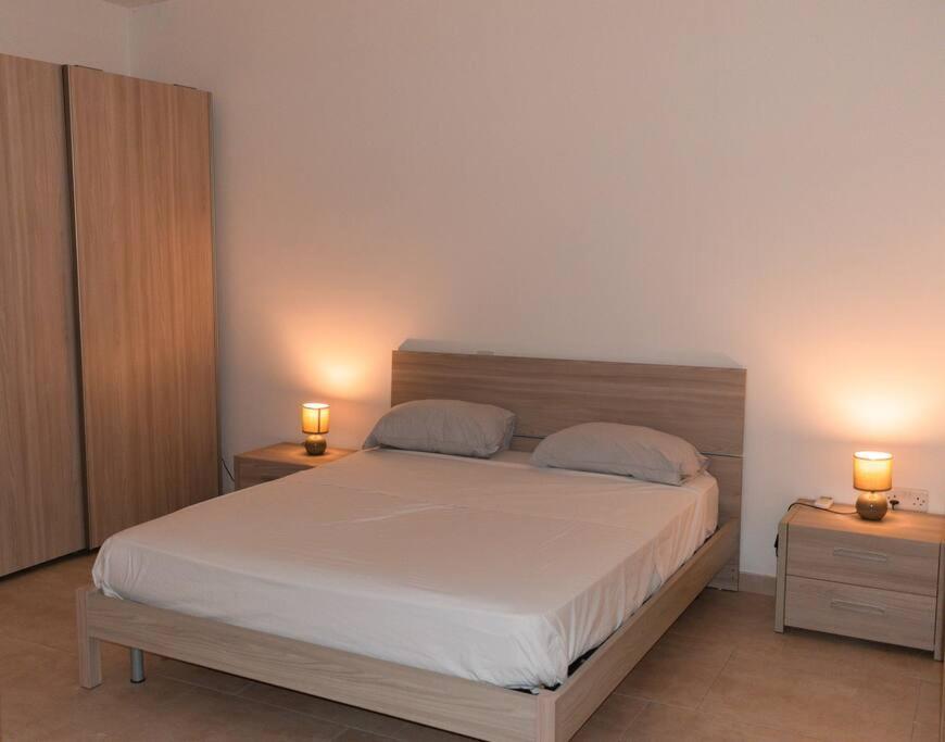 埃尔哥茨拉Central Modern Apartment 1 Bedroom的一间卧室配有一张带2个床头柜的大床