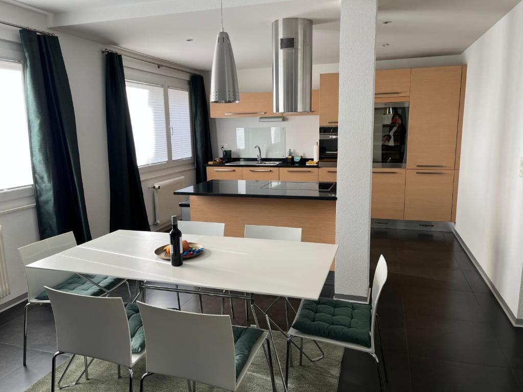 锡永Appartement Tourbillon centre-ville的用餐室以及带白色桌椅的厨房