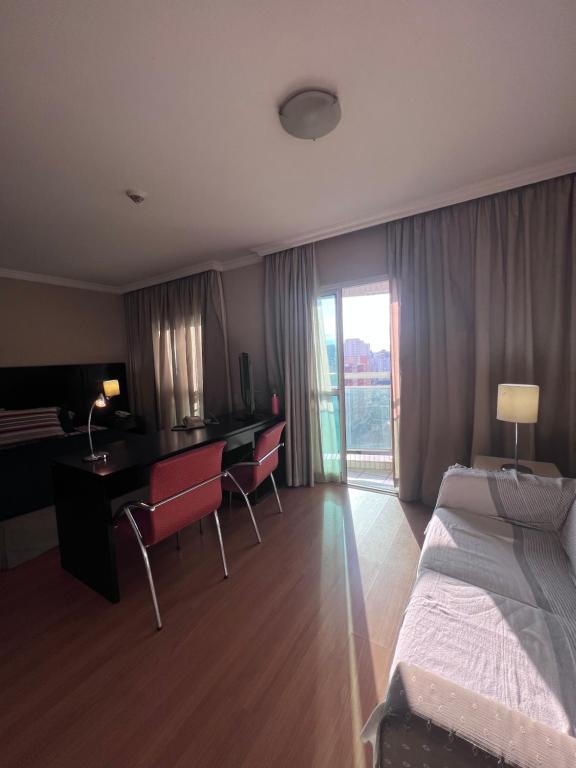 圣保罗HOTEL PERDIZES - FLAT Executivo - 1403的酒店客房 - 带一张床和一张带椅子的桌子
