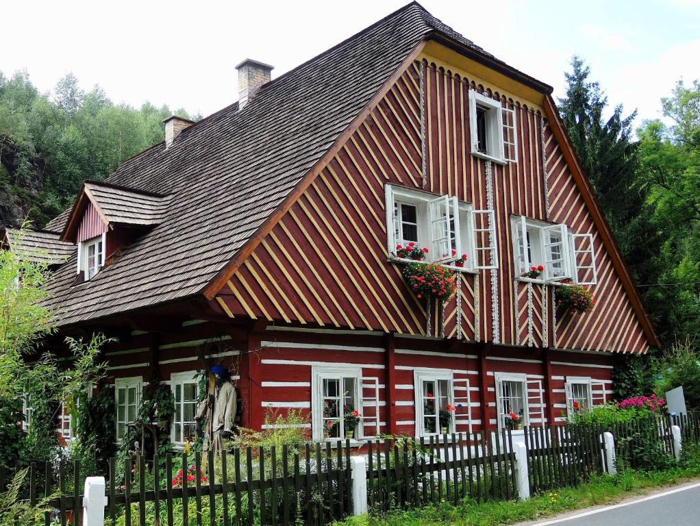 德尔内夫奥里克Mlýn u skály的红色的房子,设有白色的窗户和栅栏
