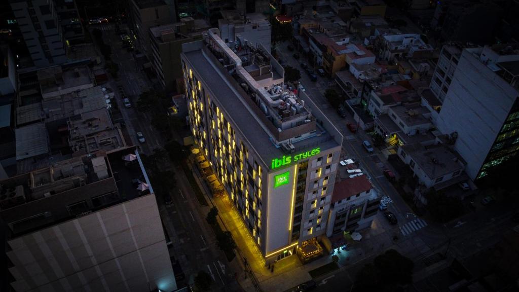 利马ibis styles Lima San Isidro的建筑的顶部景色,上面有绿色标志