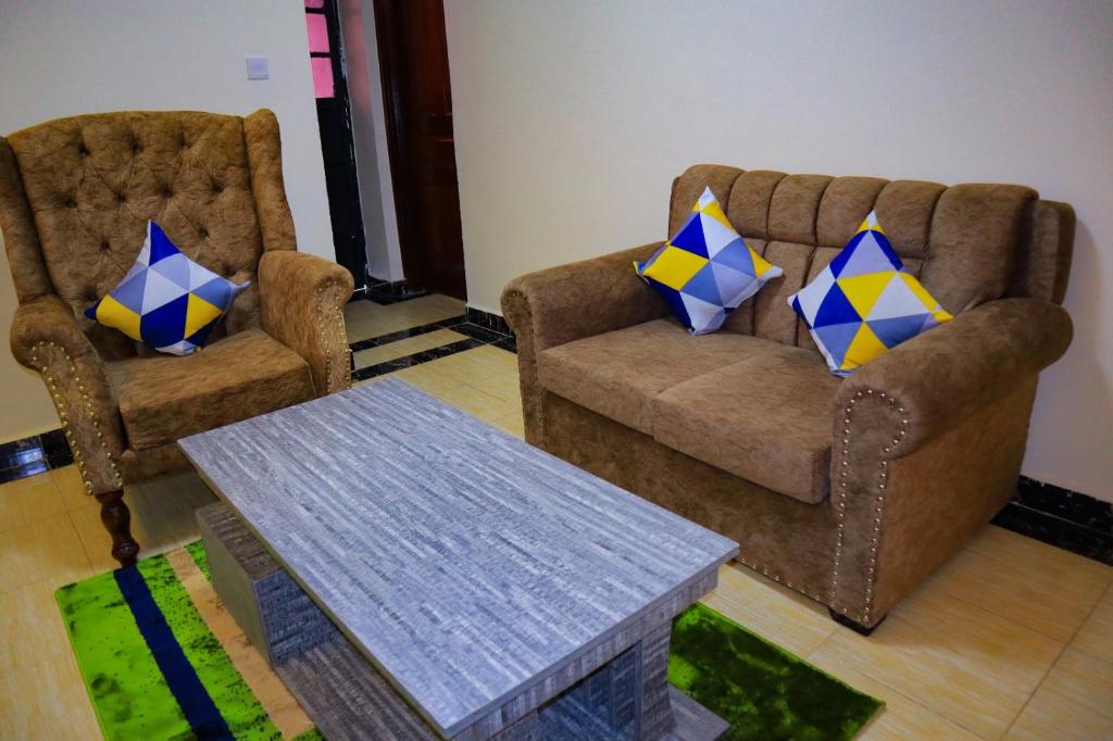 Langata RongaiSpringStone executive suite Rm 2的客厅配有两把椅子和一张桌子
