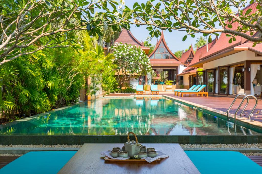 利巴诺伊Baan Tao Talay - Beachfront Private Villa的房屋前带桌子的游泳池
