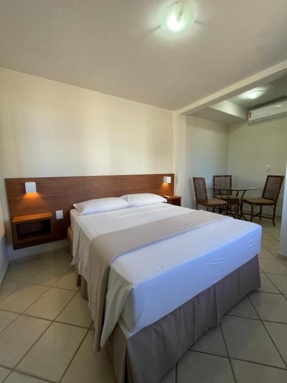 纳塔尔Pousada Laranja - Nova Administração的一间卧室配有一张大床和一张桌子及椅子