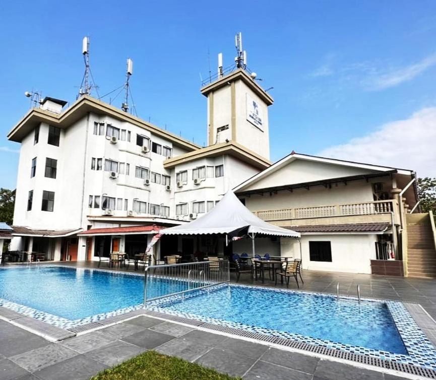 珍南海滩杨卡萨阿卡德米&兰卡威度假酒店的一座大型建筑,前面设有一个游泳池