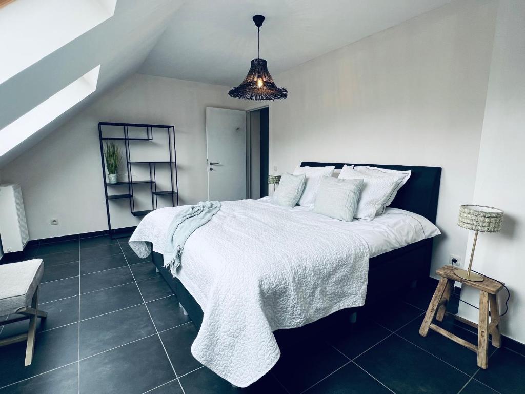 OnkerzeleZEN op Vakantie - Zen aan De Gavers的卧室配有一张带白色床单和枕头的大床。