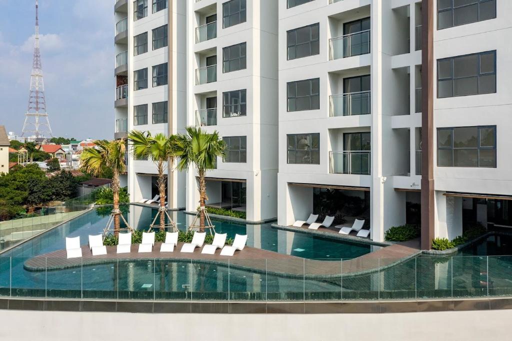 Ấp Phú ThọHoa's lovely 2-bedroom condo with pool的公寓大楼设有游泳池和棕榈树