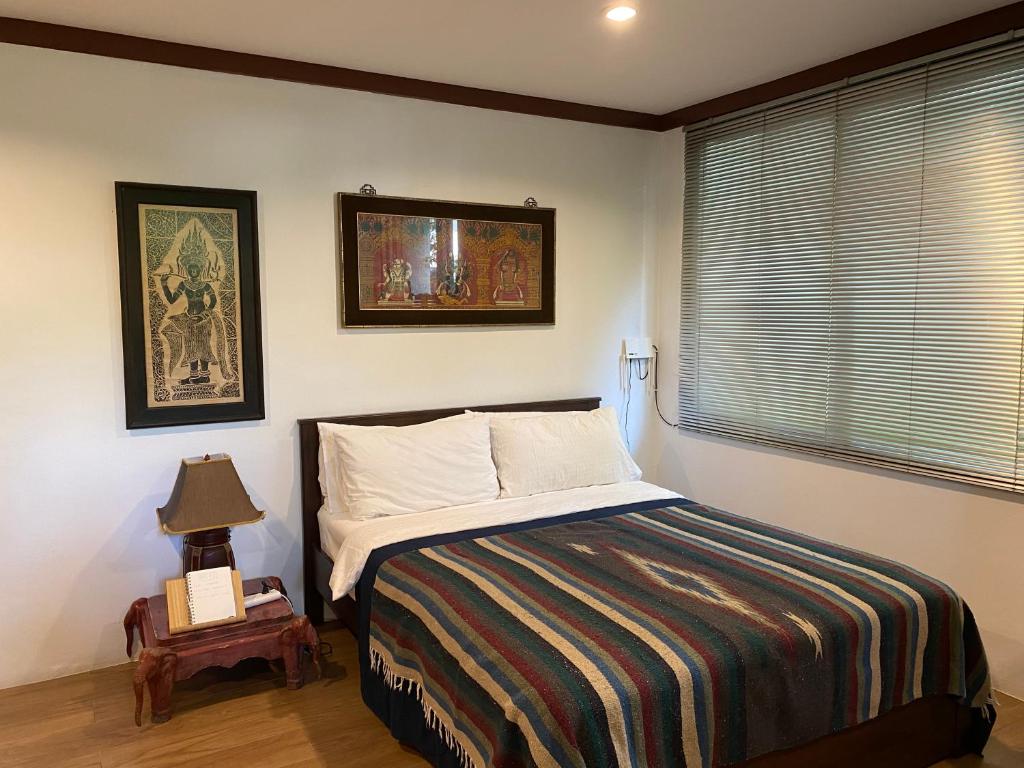 曼谷Cozycomo Bangkok的一间卧室设有一张床和一个窗口